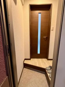a wooden door in a hallway with a staircase at 札幌中島公園徒歩圏内の宿泊施設室内はとてもおしゃれで綺麗な室内空間 in Sapporo