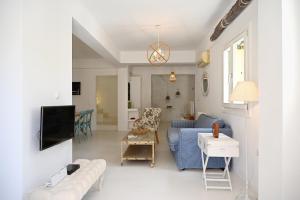 a living room with a blue couch and a tv at Terramare Villa's 4 in Kithnos