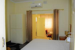 a bedroom with a bed and a desk and a chair at Yaseens B&B in Ladysmith
