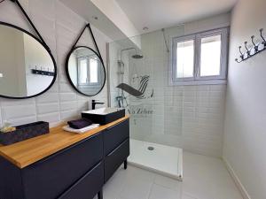 a bathroom with a sink and a mirror at La Verrerie - Maison coeur de ville avec jardin in La Tremblade