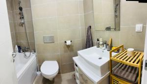 a bathroom with a white toilet and a sink at Serenity Pool&Terrace Studio by Cosmopolis in Ştefăneştii de Sus