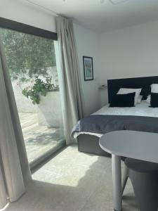 een slaapkamer met een bed en een groot raam bij En Plein cœur des calanques à 800 m de la mer in Le Rove