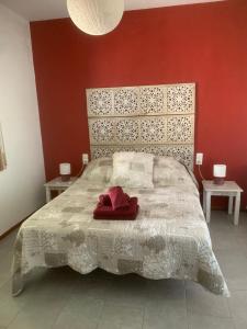 a bedroom with a large bed with a red wall at Casita Flamingo in Deltebre