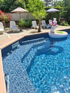 a swimming pool with a pool noodle in the middle at Gîte 4 pers, Jacuzzi privatif & Piscine & Lit cabane in Saint-Georges-sur-Cher