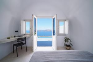 a bedroom with a desk and a view of the ocean at Santonero in Akrotiri