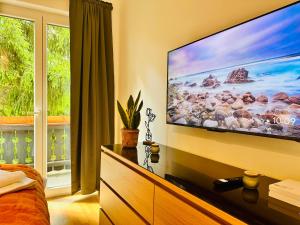 a bedroom with a large flat screen tv on a wall at Joes cozy Apartment in Payerbach