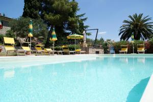 a large swimming pool with chairs and umbrellas at Dolce Vita in Campiglia Marittima