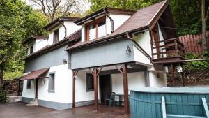 a white house with a blue fence in front of it at Pinewood Cabin in Braşov