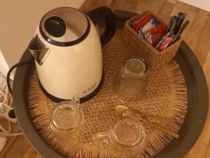 a tea pot and two glasses on a plate at La maison de Louise in Séné +7 photos