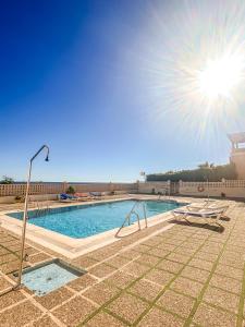 a large swimming pool with a sun shining in the sky at Precioso apartamento en el Calón Playa con vistas y piscina in El Calón +24 photos
