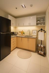 a kitchen with a refrigerator and a sink at Elegant 1BR near Solaire, Okada, Mall of Asia in Manila