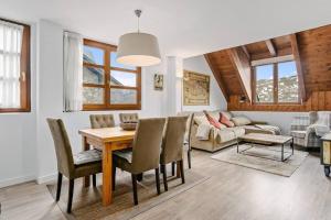 a living room with a table and chairs and a couch at ICIAR - Dúplex by Cardi Suites in Formigal