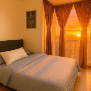 a bedroom with a bed and a window with a sunset at Elegant 1BR near Solaire, Okada, Mall of Asia in Manila