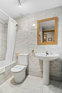 a bathroom with a toilet and a sink and a mirror at El Mirador by Cardi Suites in Formigal