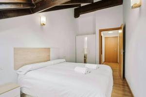 a bedroom with a white bed with two towels on it at LINA by Cardi Suites in Escarrilla