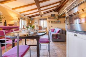 Una cocina y una sala de estar con mesa y sillas. en la Soffitta, en Campiglia Marittima