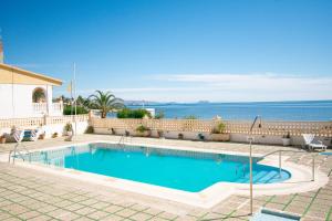 a swimming pool with the ocean in the background at Cómodo apartamento en El Calón Playa frente al mar in El Calón