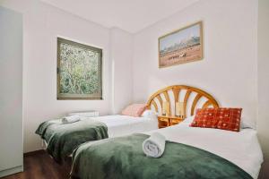 a bedroom with two beds and a window at La Casita del Arbol by Cardi Suites in Sallent de Gállego