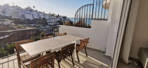 a table and chairs on a balcony with a view of the city at Hacienda 22 MENYBER in Nerja