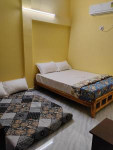 a bedroom with two beds in a room at Kamal Rooms in Tiruvannāmalai