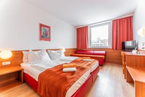 a hotel room with a bed and a television at OEKOTEL Salzburg Messe in Salzburg