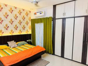 a bedroom with a bed and a green curtain at Gulmohar Villa in Indore
