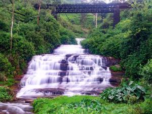una cascata su un fiume con un ponte sullo sfondo di Stay Logi Nanuoya a Nanu Oya