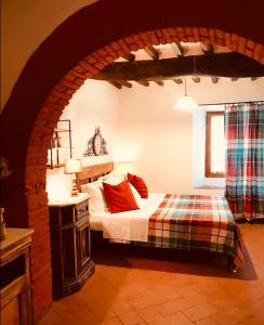 a bedroom with a bed in a room with an archway at Camera e Appartamento Toscana - B&B Palazzo Robicci in Castiglion Fiorentino