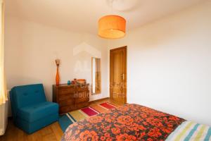 Un dormitorio con una cama y una silla azul. en Infinity Waves by ACasadasCasas, en Ericeira 13 fotos más