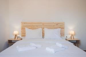 a bedroom with a white bed with towels on it at Amar V in Lechaio +87 photos