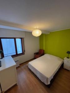 a bedroom with a white bed and a green wall at Porto - Sunset flat at the beach - Free parking in Matosinhos