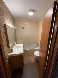 a bathroom with a sink and a toilet and a tub at Porto - Sunset flat at the beach - Free parking in Matosinhos +22 photos