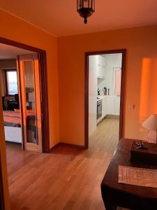 a living room with orange walls and wooden floors at Porto - Sunset flat at the beach - Free parking in Matosinhos