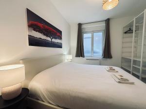 une chambre avec un grand lit blanc et une fenêtre dans l'établissement 1 Clairmarais T2 cosy a 2 pas du centre-ville, à Reims