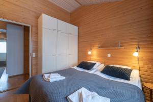 a bedroom with a large bed and a wooden wall at Kuukkeli Apartments Suite in Saariselka