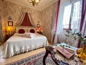 a bedroom with a bed with red pillows on it at Camera Romantica con Giardino in Dimora Storica - B&B Palazzo Robicci in Castiglion Fiorentino