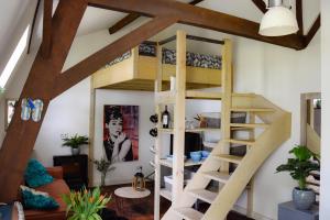 a loft bed in a room with a spiral staircase at Bed and Breakfast 'Op de Kleijne Hei' in Well