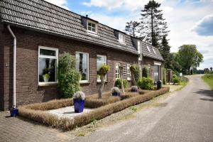 a brick house with potted plants in front of it at Bed and Breakfast 'Op de Kleijne Hei' in Well