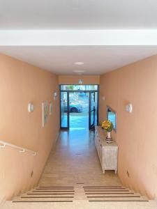 a hallway with a table and a door with a vase on it at Hotel Residence Ponente in Cesenatico