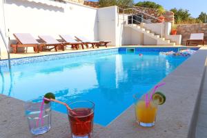 two cocktails sitting on a bar next to a swimming pool at Villa Lavanda Korčula in Zavalatica