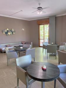 a living room with tables and chairs and a couch at Hotel Residence Ponente in Cesenatico +54 photos