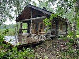 a log cabin in the middle of a forest at Nivan Majoitus in Joensuu