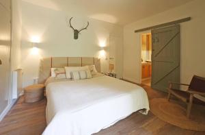 een slaapkamer met een groot wit bed met een antilope hoofdeinde bij Golf Beach Pals Haus - The Haus Bcn in Pals