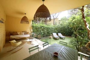 een patio met een bed en stoelen en een tafel bij Golf Beach Pals Haus - The Haus Bcn in Pals