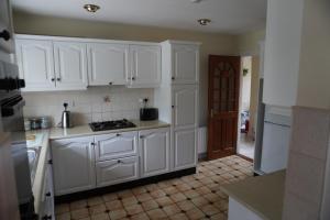 a kitchen with white cabinets and a stove at Atlantic Lodge in Ballyshannon +11 photos
