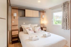 a bedroom with a large white bed with two pillows at Bois d'amour - Piscine - Terrasse in Dinard