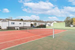 a tennis court with a net on top of it at Bois d'amour - Piscine - Terrasse in Dinard