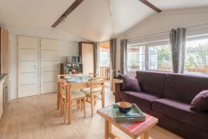 a living room with a couch and a table at Bois d'amour - Piscine - Terrasse in Dinard