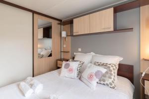 a bedroom with a bed with white sheets and pillows at Bois d'amour - Piscine - Terrasse in Dinard +7 photos