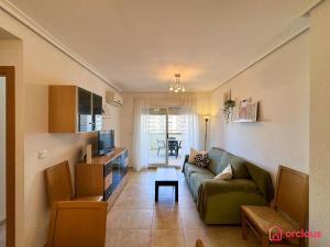 a living room with a green couch and a table at Rincón Ideal in Oropesa del Mar +45 photos